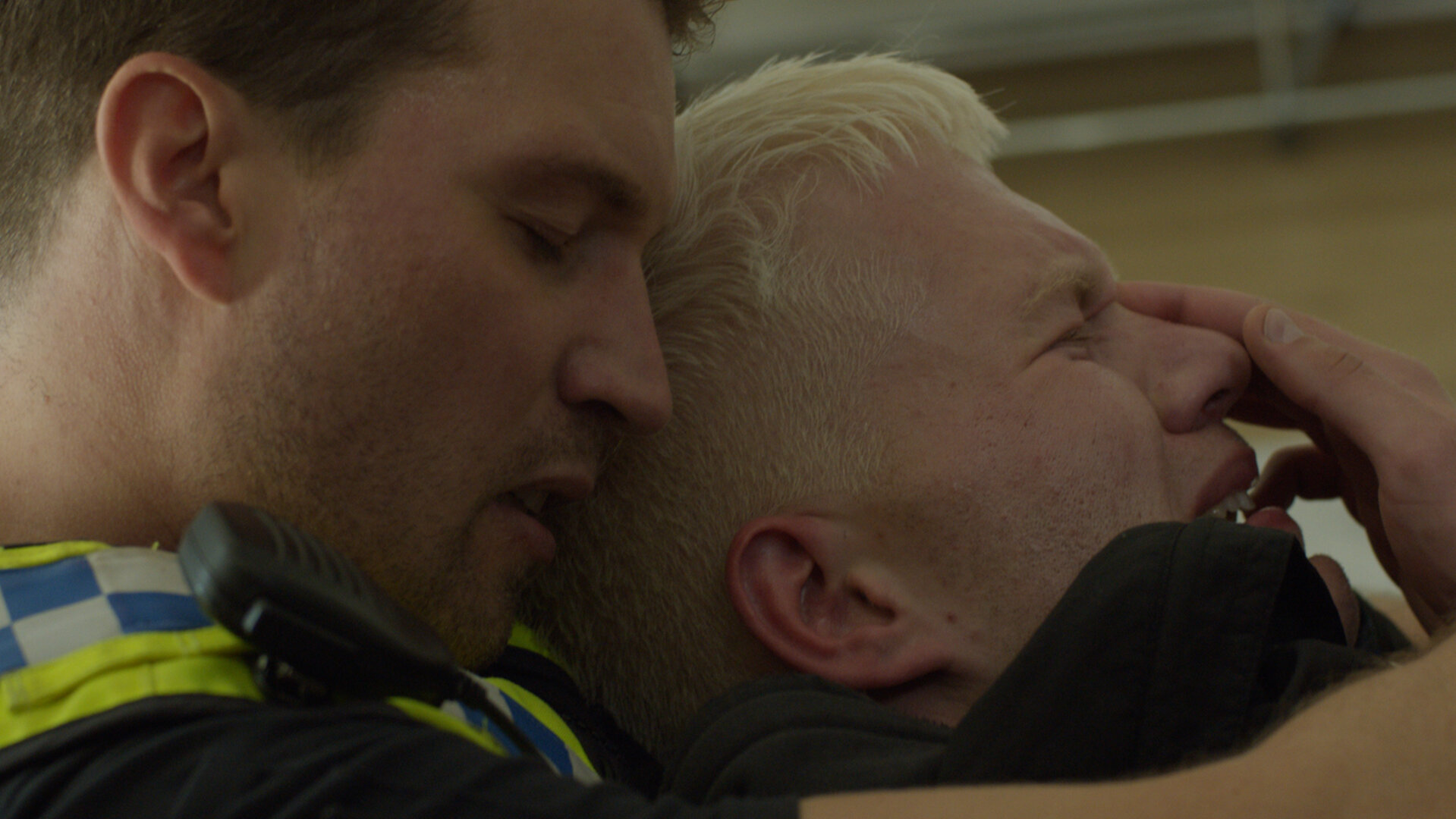 "Notruf Hafenkante - Kalter Entzug": Großaufnahme: Die Gesichter des Polizisten Nick Brandt (Raúl Richter) und seines Halbbruders Finn (Antonije Stankovic) liegen eng beieinander. Nick steht hinter Finn. Er hat seine Arme um ihn gelegt. Finns Augen sind geschlossen er scheint zu weinen, Nicks Augen sind ebenso geschlossen.
