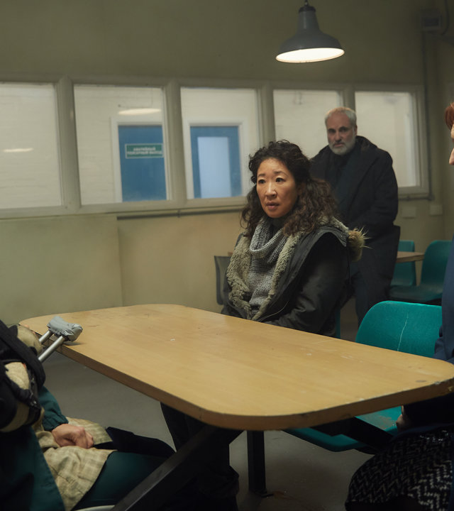"Killing Eve - Steckt mich ins Loch": Nadja (Olivia Ross) sitzt Eve (Sandra Oh) und Carolyn Martens (Fiona Shaw) an einem Tisch im Besuchszimmer eines Gefängnisses gegenüber. Die Frauen am Tisch schauen sich ernst an, während Konstantin (Kim Bodnia) im Hintergrund das Gespräch beobachtet.