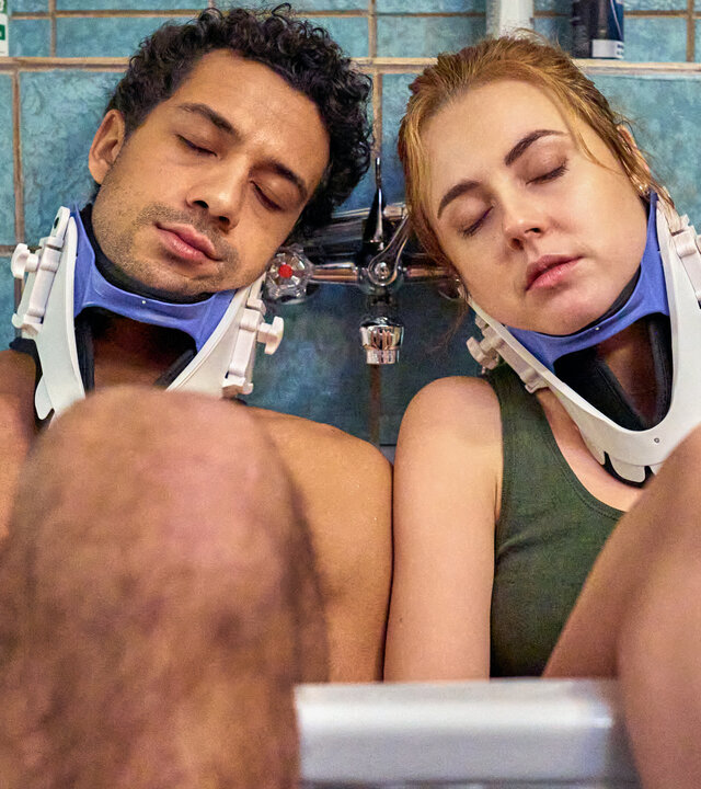"Ich dich auch! - Das Herz": Yannik (Rojan Juan Barani) und Caro (Meriel Hinsching) sitzen mit geschlossenen Augen in der Badewanne. Beide tragen eine Halskrause. Sie lehnen sich an der Wand an. Ihre Beine hängen aus der Wanne heraus.