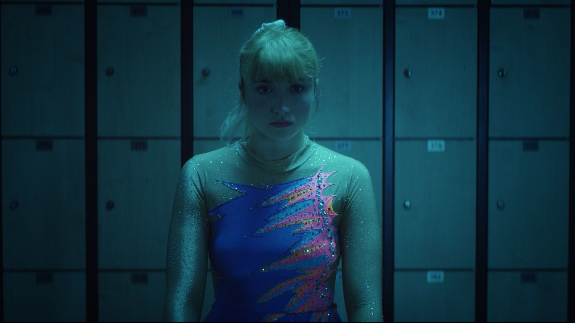 "Derby Girl - Das Auge des Tigers": In einer Umkleidekabine. Lola Bouvier (Chloé Jouannet) trägt einen Gymnastikanzug und blickt ernst.