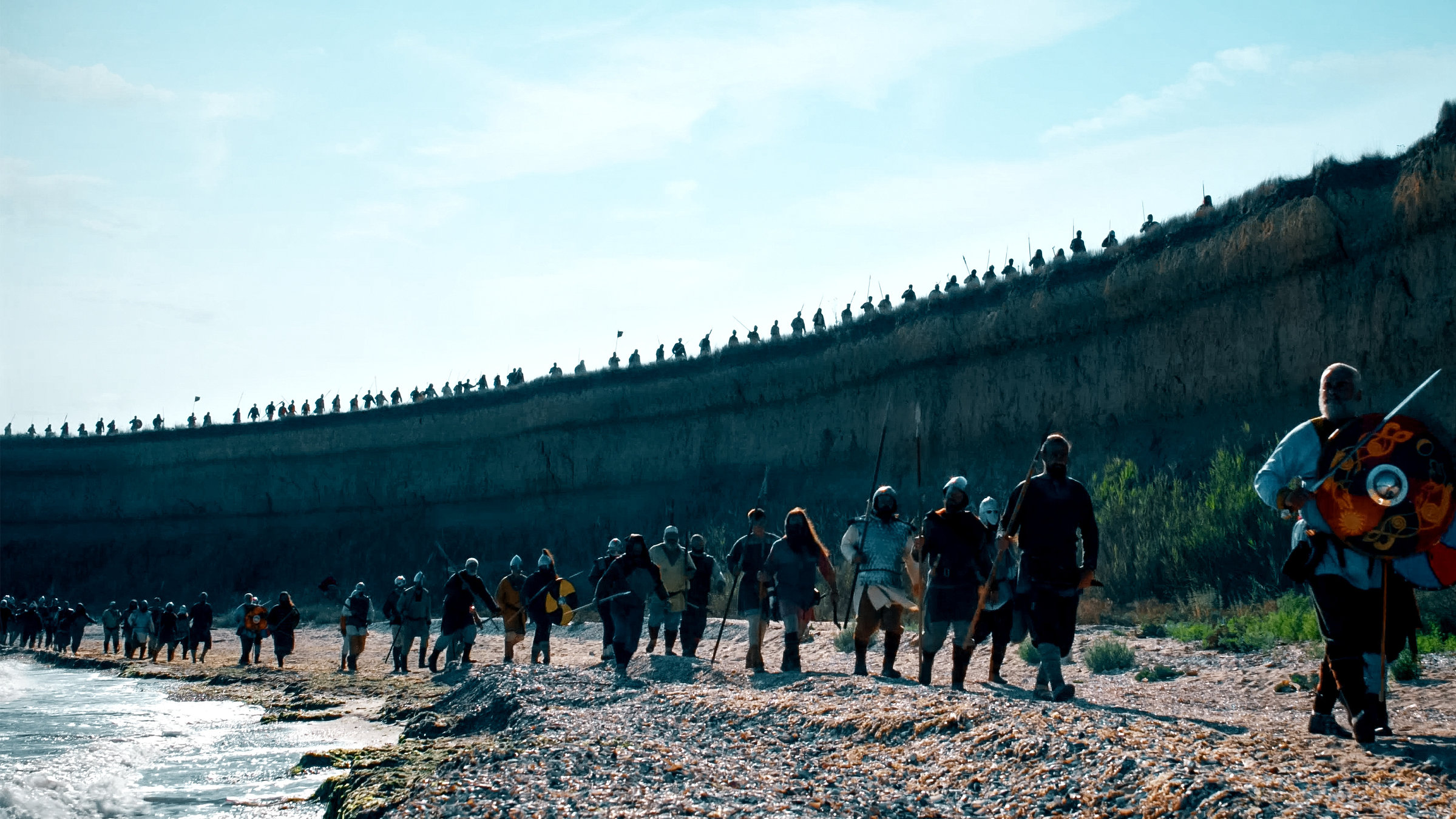 "Terra X: Mythos Nordsee - Wilde Küsten, Götter und segelnde Drachen": Mit Schwertern bewaffnete Männer gehen am Nordseestrand entlang.