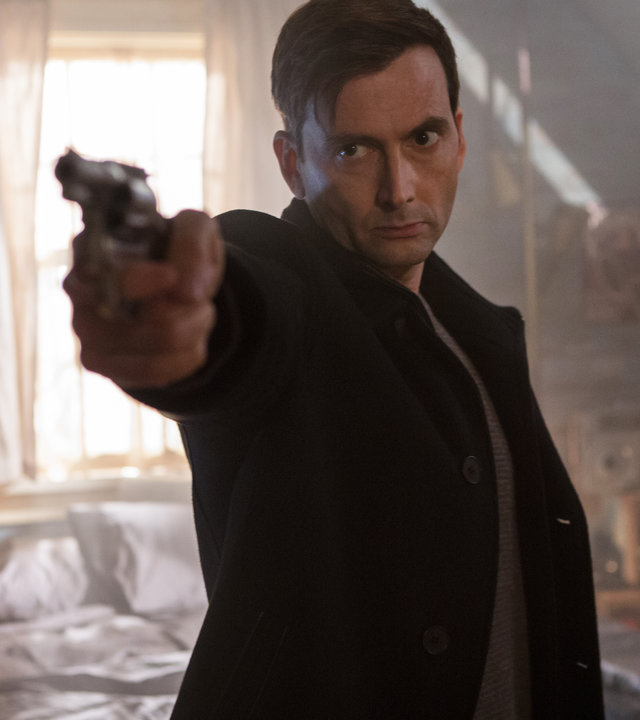 "Im Visier des Killers": Cale Erendreich (David Tennant) steht mit gezogener Waffe in einem Schlafzimmer.