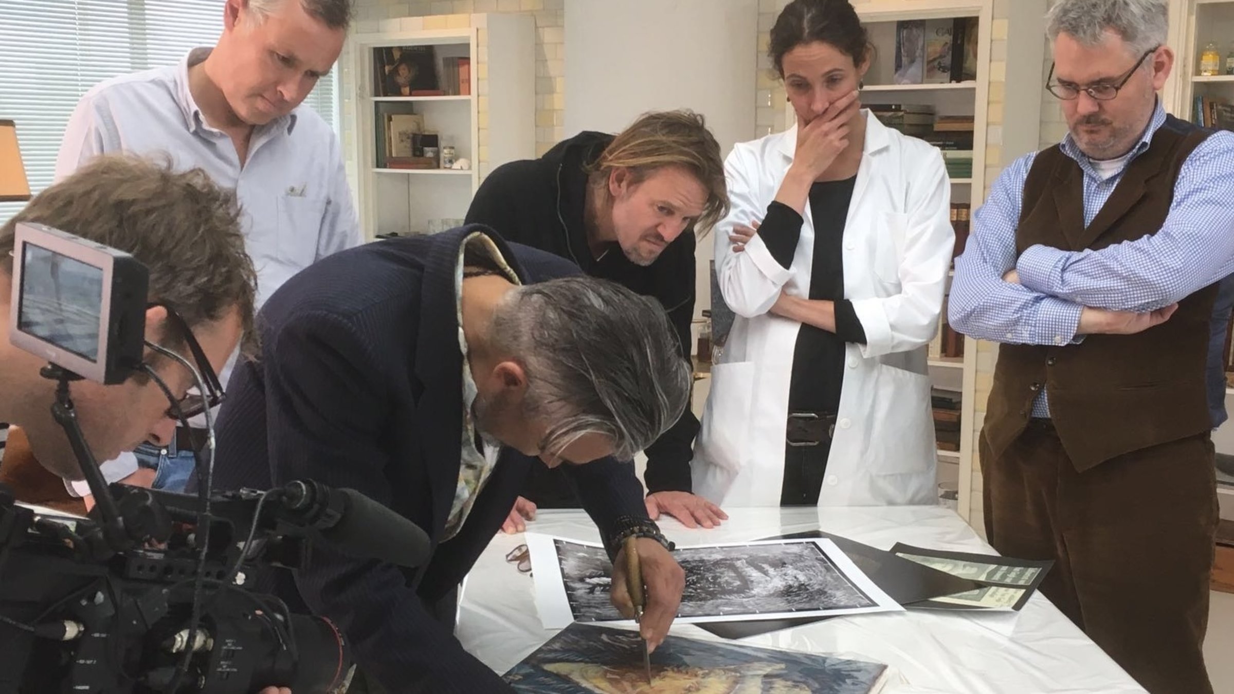 "Das Geheimnis der Meister - Van Gogh": Ein Mann schneidet mit einem Messer in ein vor ihm liegendes van Gogh-Bild, umgeben von einer Gruppe, die darauf starrt.