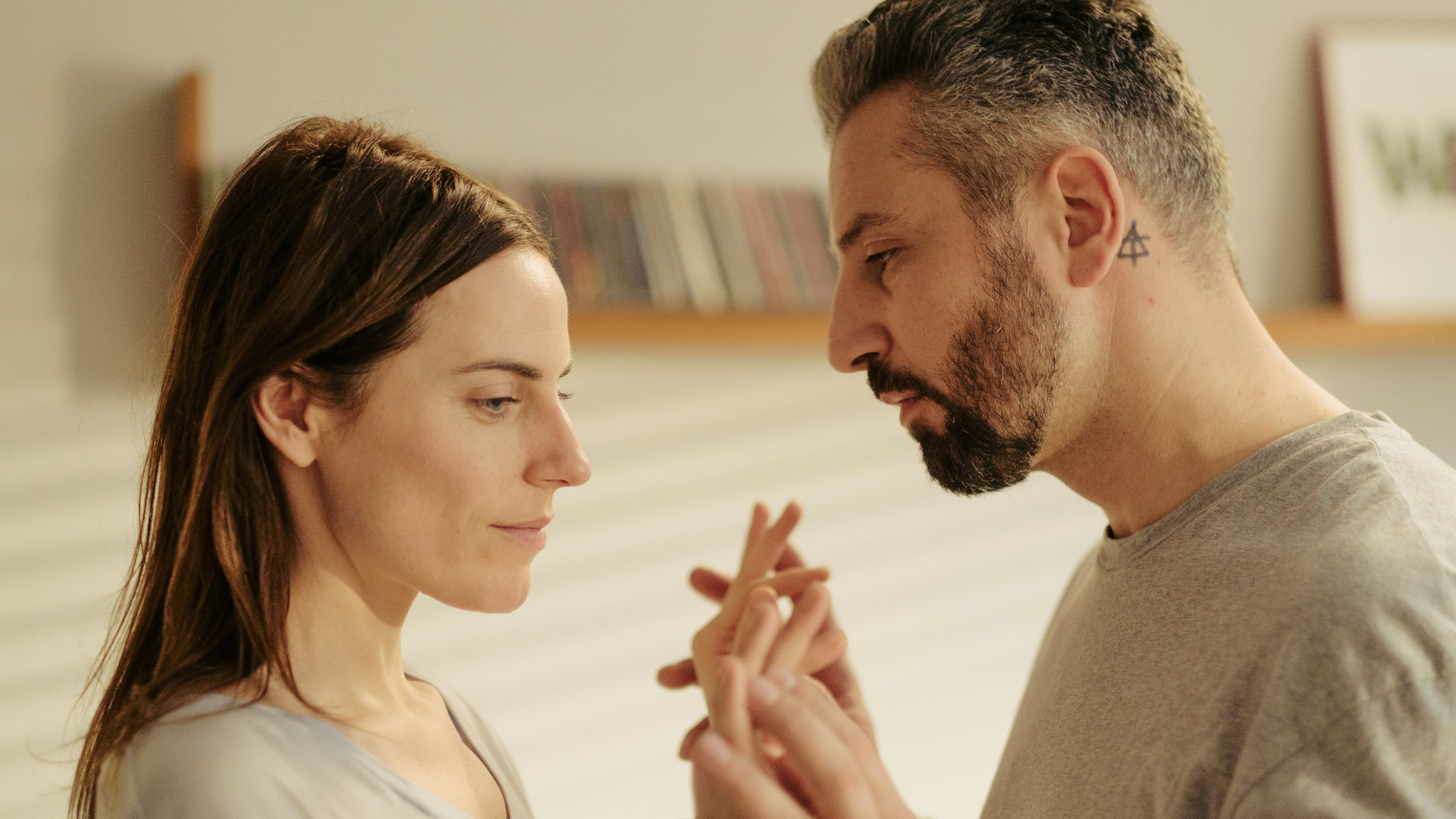 "Am Anschlag - Die Macht der Kränkung - GEORG": Eva (Antje Traue) und Georg (Murathan Muslu) stehen sich gegenüber und halten sich an den Händen.