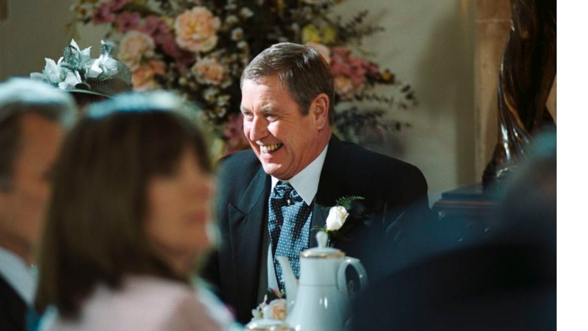 "Inspector Barnaby - Midsomer Rhapsody - Melodie des Todes": Inspector Barnaby (John Nettles) lachend am Tisch einer Hochzeitsgesellschaft.