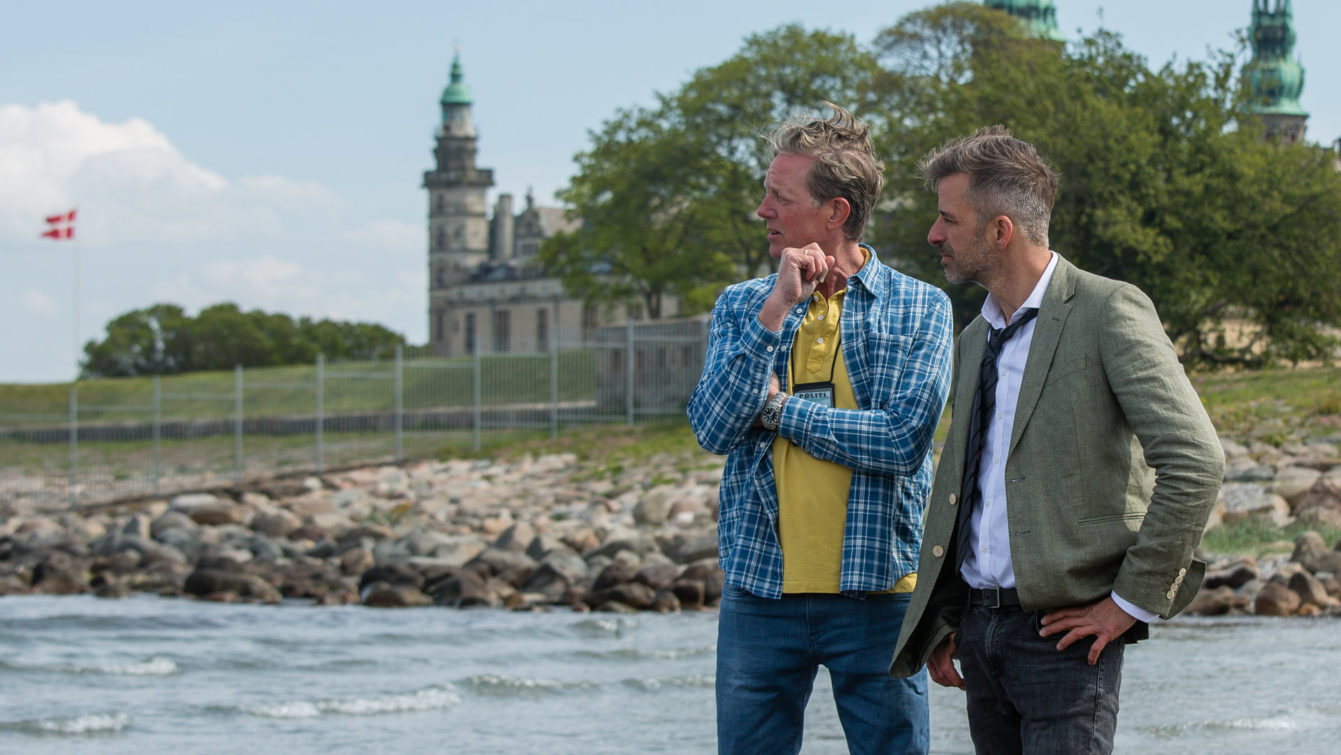 "Dan Sommerdahl – Tödliche Idylle": "Dan Sommerdahl - Die Tote am Strand": Polizist Dan Sommerdahl (Peter Mygind) und sein Kollege Flemming Torp (André Babikian) stehen am Strand von Helsingør.