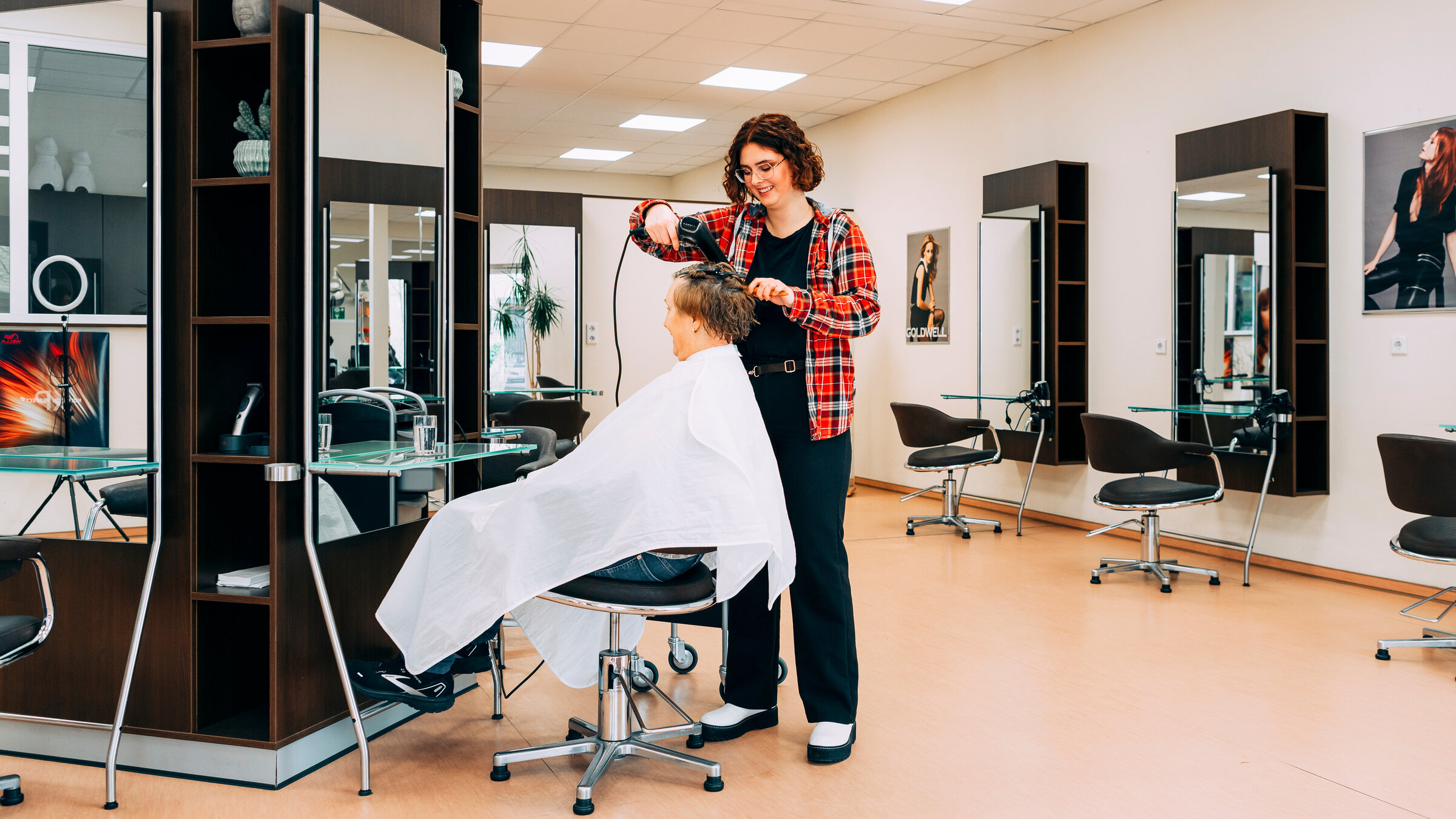 "Einfach Mensch - Mein Weg auf den ersten Arbeitsmarkt": Anna- Lena frisiert eine Kundin im Friseursalon.