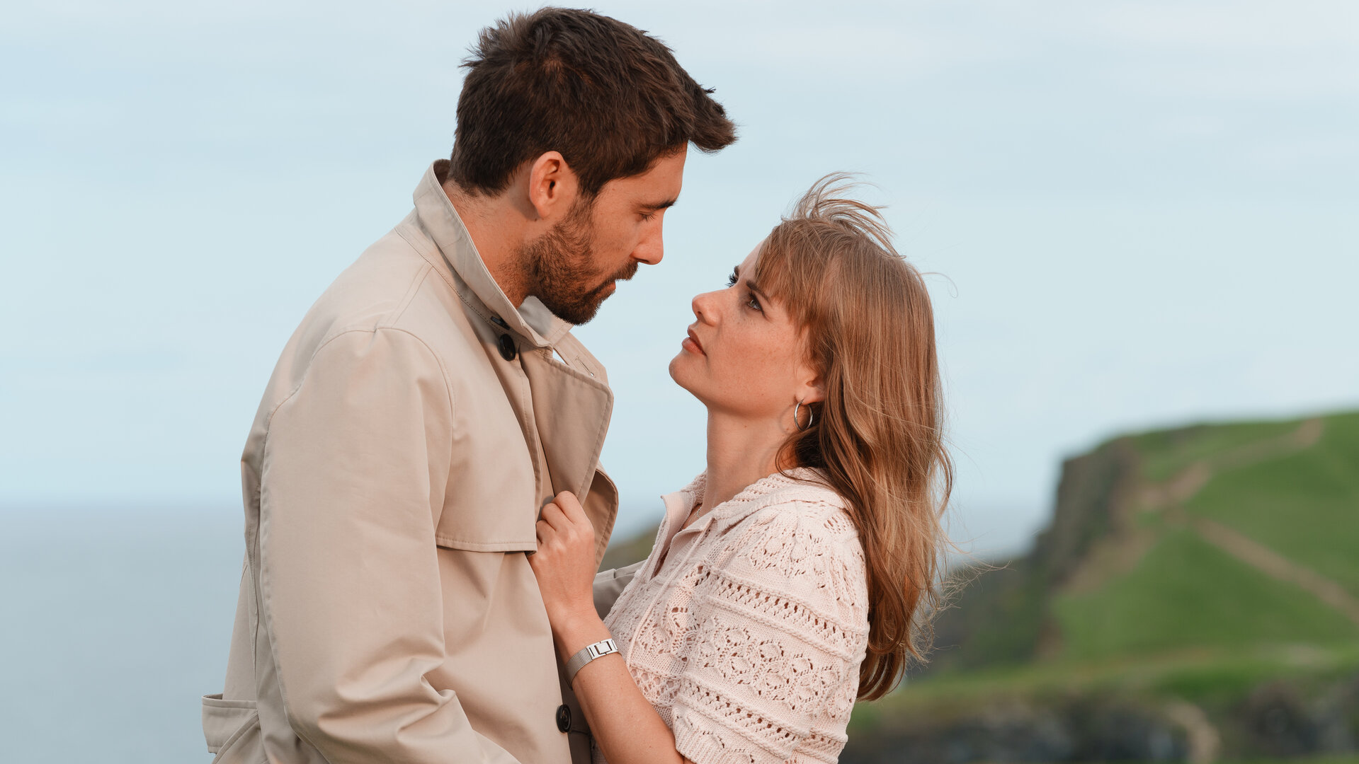 "Rosamunde Pilcher: Einspruch für die Liebe": An der Küste Cornwalls: Johanna Rashford (Anna Hausburg) und Bill Reynolds (Kerim Waller) stehen eng beieinander und blicken sich tief in die Augen.