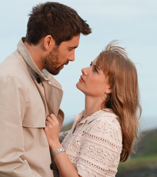 "Rosamunde Pilcher: Einspruch für die Liebe": An der Küste Cornwalls: Johanna Rashford (Anna Hausburg) und Bill Reynolds (Kerim Waller) stehen eng beieinander und blicken sich tief in die Augen.