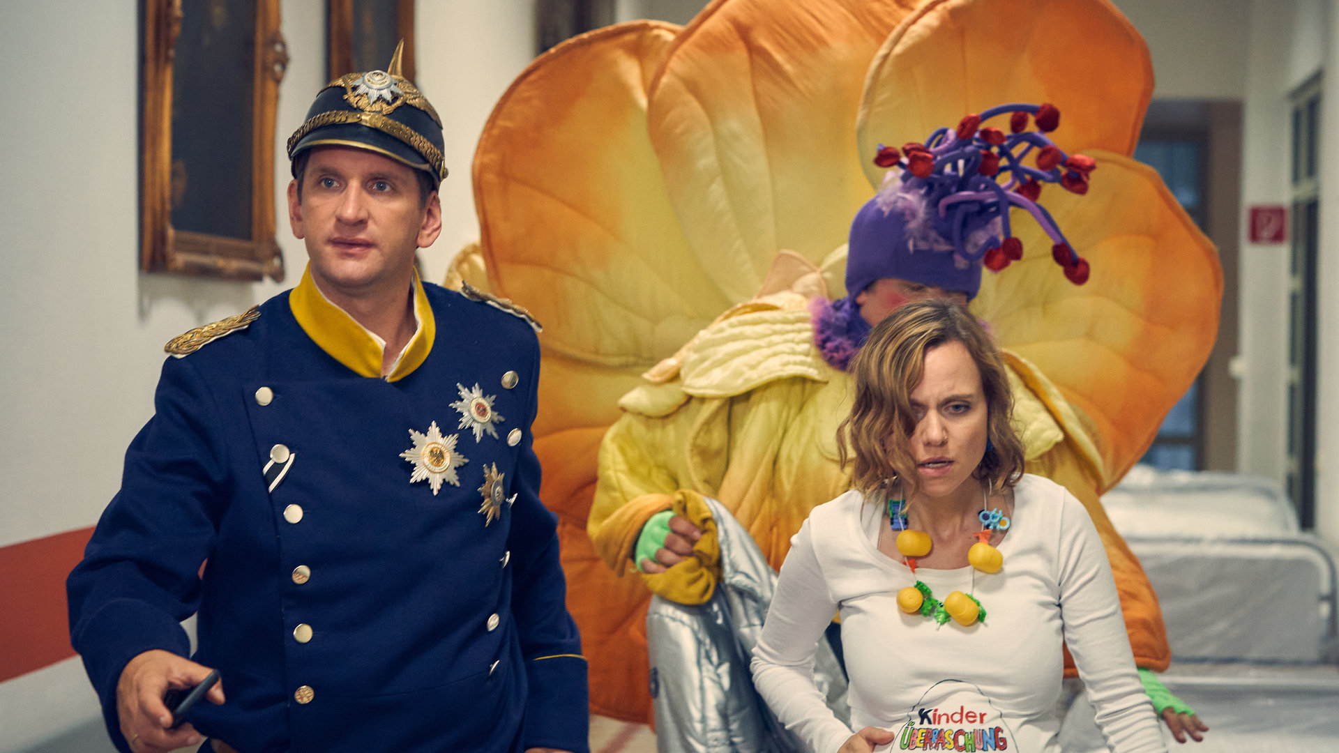 "Andere Eltern 2 – Episode 1": Lars (Sebastian Schwarz), Malte (Daniel Zillmann) und Anita (Nadja Becker) laufen in ihren Karnevalskostümen den Gang im Krankenhaus entlang.