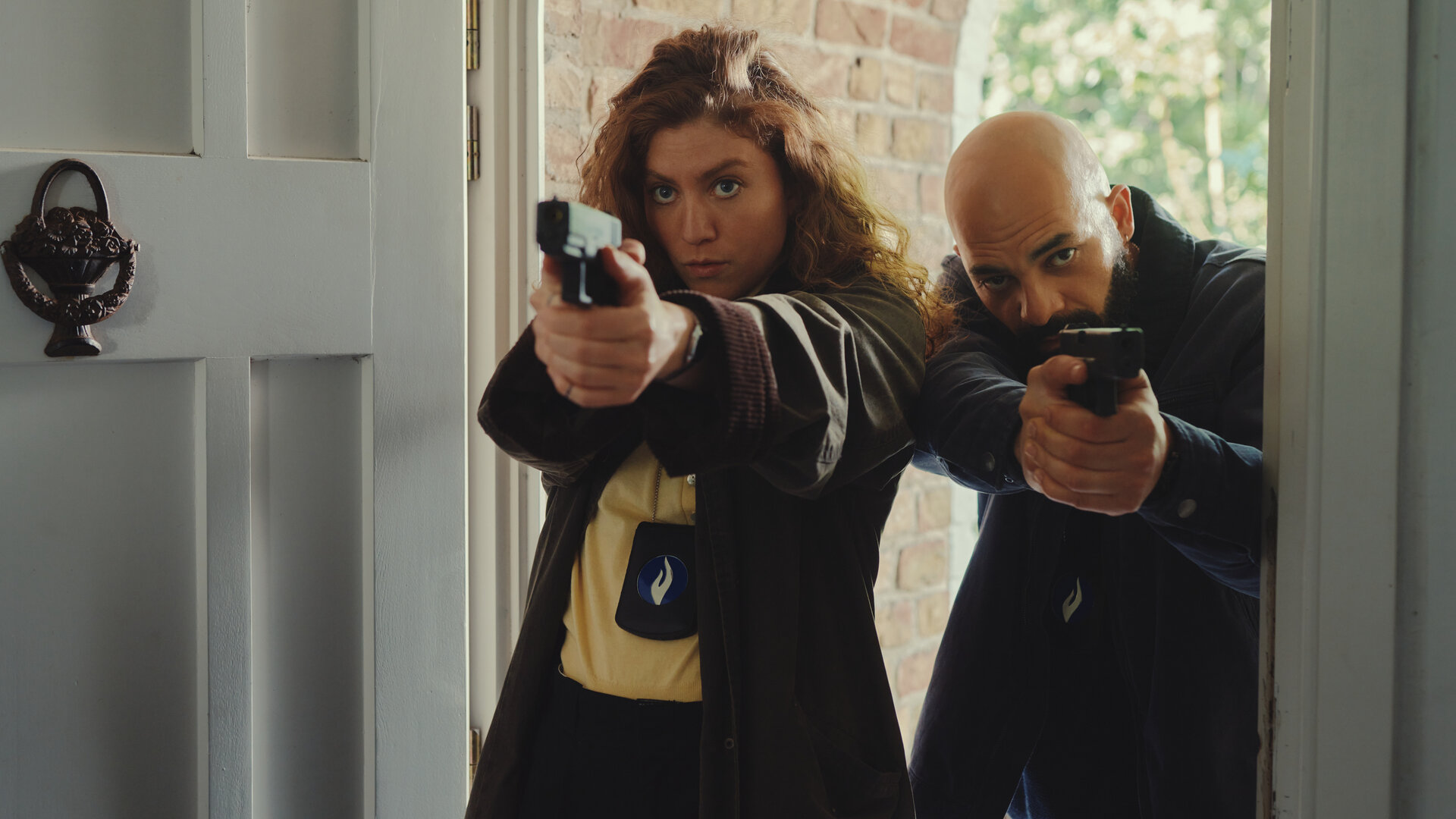 "Juliet - Der Kreis der Frauen": Juliet Dumon (Charlotte De Bruyne) und ihr Kollege Jamal Haout (Nabil Mallat) stehen mit gezogenen Dienstwaffen in der Eingangstür eines Hauses.