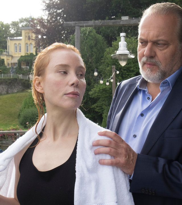 "Der Alte - Das perfekte Glück": Nora Schubert (Franziska Petri) und Hauptkommissar Richard Voss (Jan-Gregor Kremp) stehen auf einem Steg am See. Voss legt Nora, die gerade schwimmen war, ein Handtuch über die Schultern, und sieht sie skeptisch an. Nora hat den Blick von ihm abgewandt.
