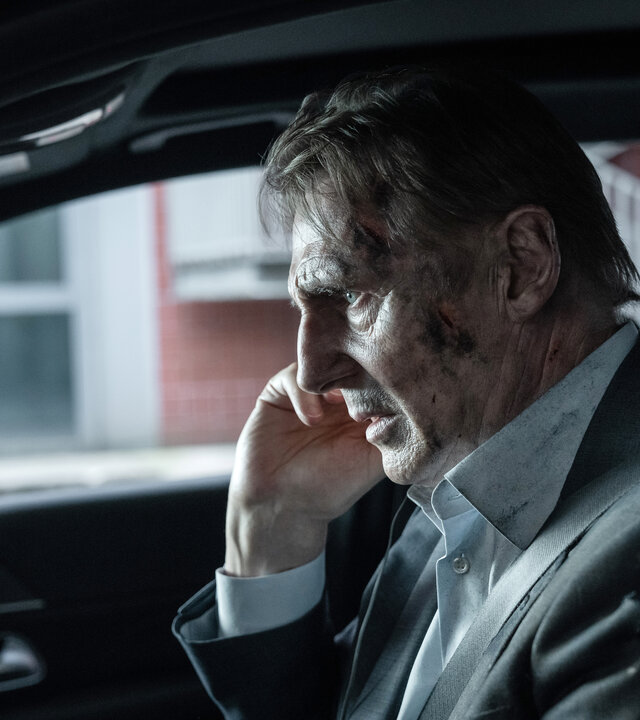 "Retribution - Vergeltung": Nahaufnahme: Matt (Liam Neeson) sitzt mit verschmutztem Gesicht und angespanntem Blick im Auto am Steuer.