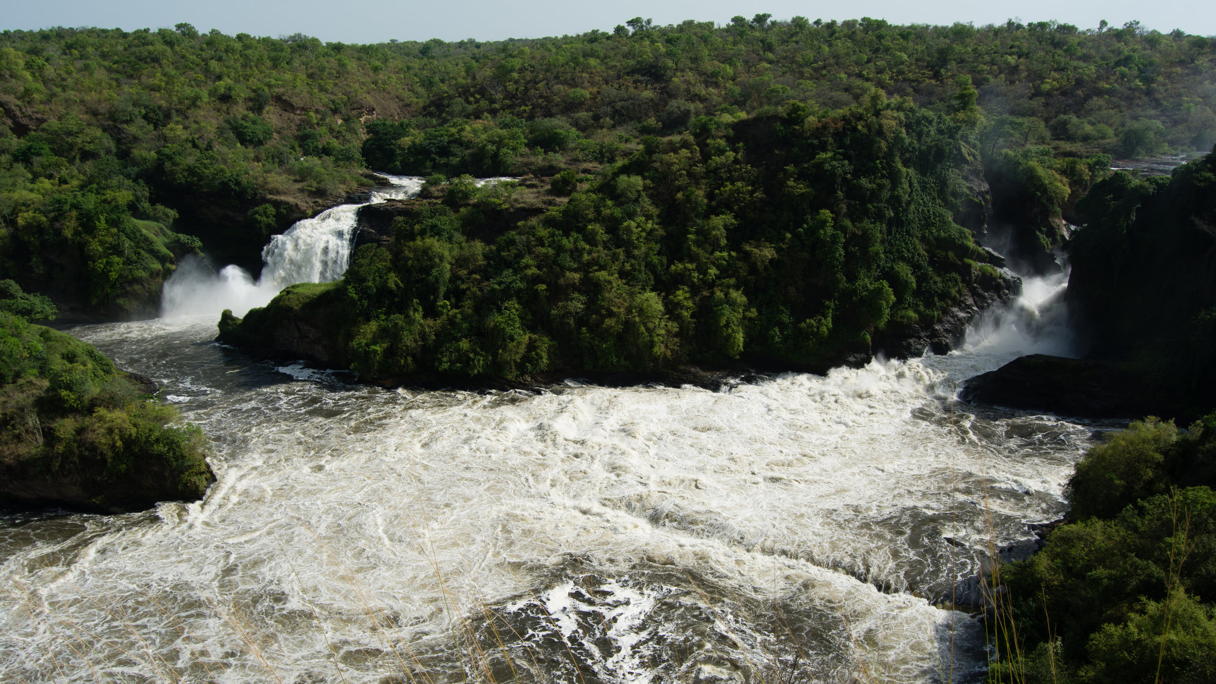 "Die wilden Flüsse Afrikas - Nil": Totale eines Wasserfalls mit zwei Flussarmen in bewaldeter Landschaft.