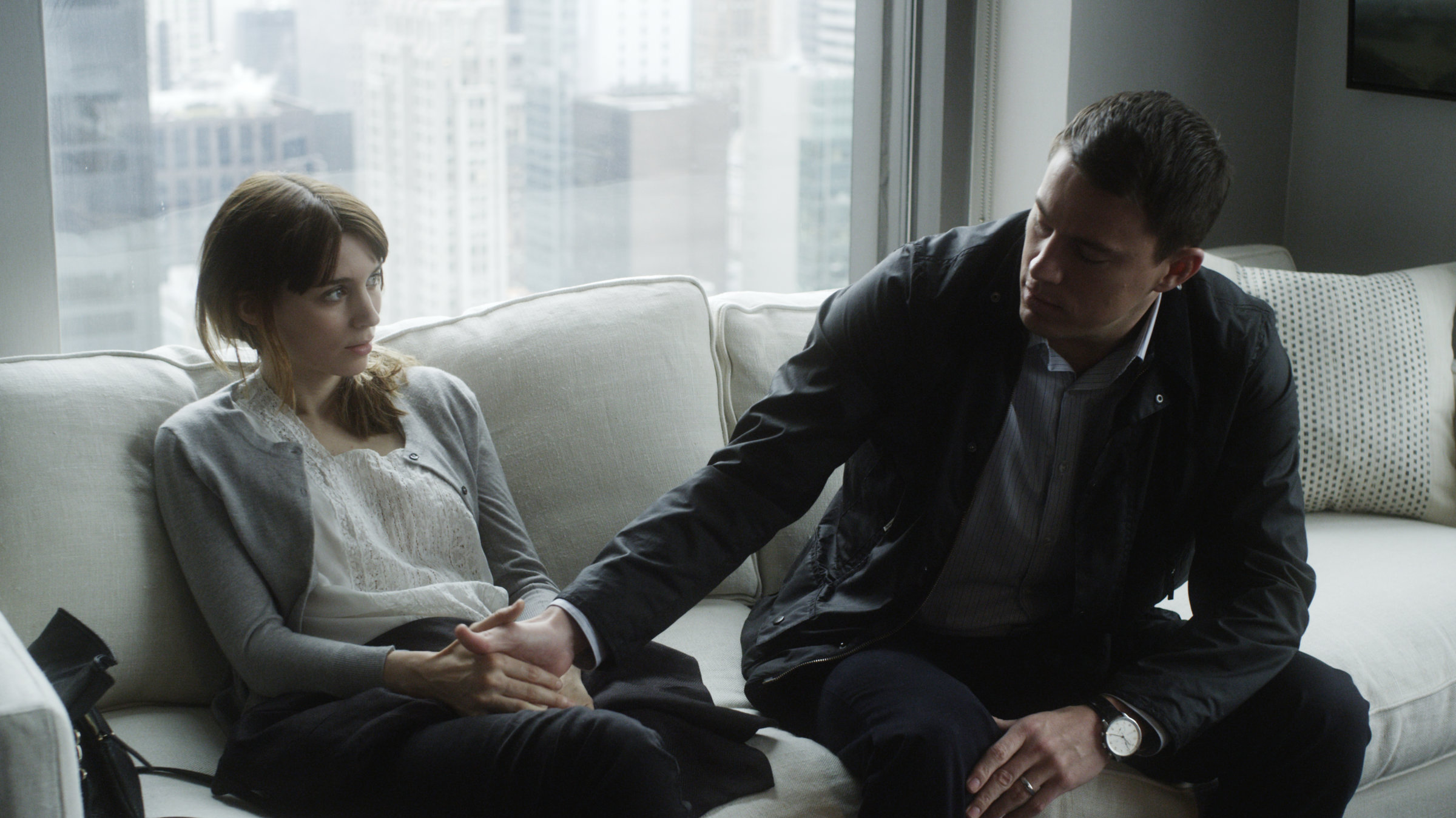 "Side Effects - Tödliche Nebenwirkungen": Emily (Rooney Mara) und Martin (Channing Tatum) sitzen nebeneinander auf dem Sofa. Martin hält Emilys Hand und sieht sie an.