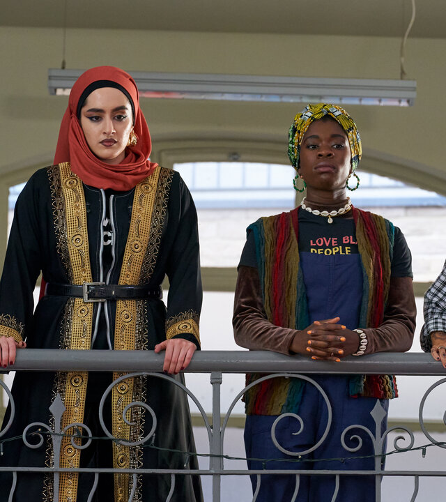 "We are Lady Parts - Spiel was vor": Momtaz (Lucie Shorthouse), Ayesha (Juliette Motamed), Bisma (Faith Omole) und Saira (Sarah Kameela Impey) stehen nebeneinander an einem Geländer und blicken konzentriert nach unten. Ihre Kleidung betont ihre Unterschiedlichkeit und bringt den individuellen Stil jeder Einzelnen zum Ausdruck.