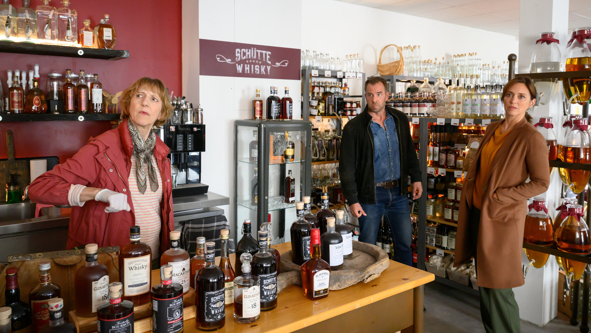 "SOKO Wismar – Ein letzter Schluck": Dr. Helene Sturbeck (Katharina Blaschke), Lars Pöhlmann (Dominic Boeer) und Karoline Joost (Nike Fuhrmann) blicken sich im Whiskyladen "Whisky Schütte" um.
