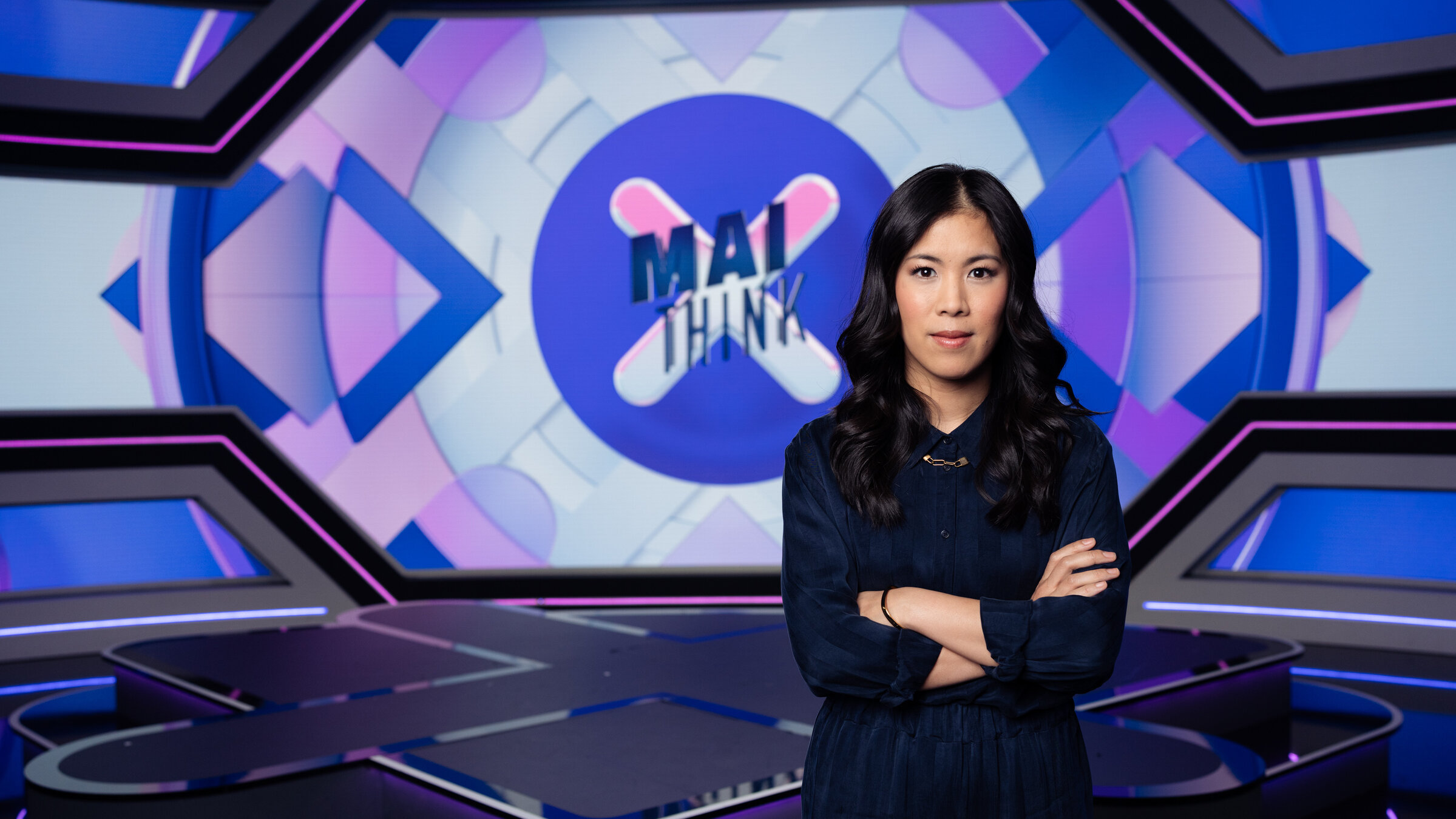 "MAITHINK X - Die Show - Die größten Mythen der Energiewende": Mai Thi Nguyen-Kim steht mit verschränkten Armen auf der Bühne vor dem Sendungslogo.