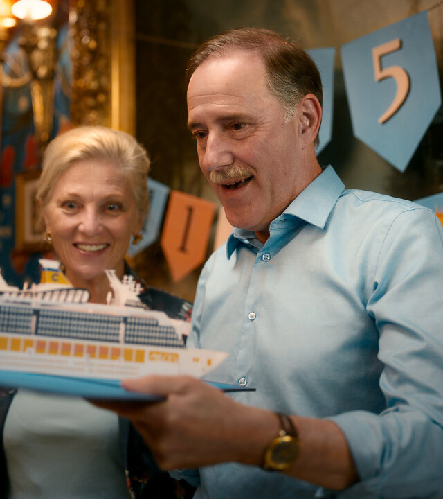 "Die goldenen Jahre": Alice Waldvogel (Esther Gemsch) und Peter Waldvogel (Stefan Kurt) stehen nebeneinander in einem Saal. Peter Waldvogel (Stefan Kurt) hält das Modell eines Kreuzfahrtschiffes in der Hand.