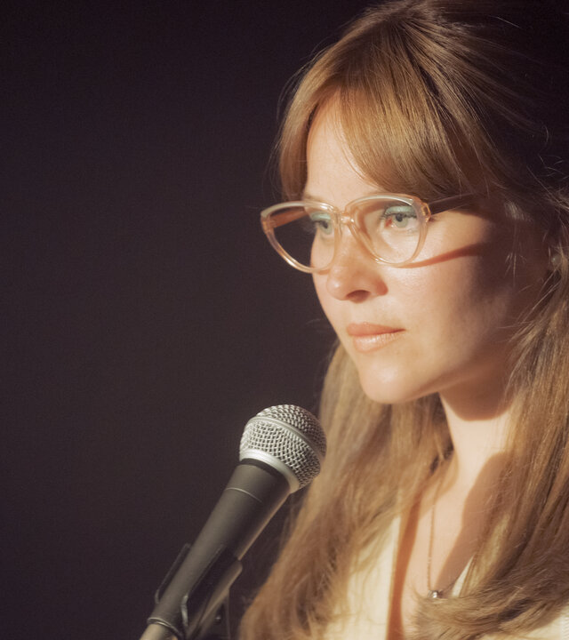 "Ku'damm 77": In einem Musikclub steht Monika Franck-Schöllack (Sonja Gerhardt) auf der Bühne und hat ein Mikrofon vor sich. Sie sieht unsicher in die Richtung des Publikums.