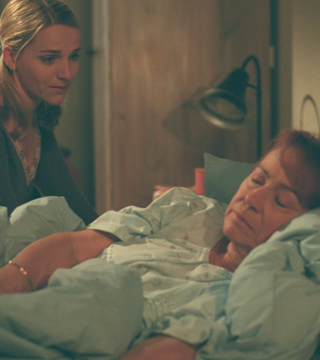 "Bianca - Wege zum Glück: Folge 50": Angst um ihre Oma: Während Oma Ursula (Annemone Haas) schläft, sitzt Bianca (Tanja Wedhorn) neben ihr am Bett und schaut sie liebevoll an.
