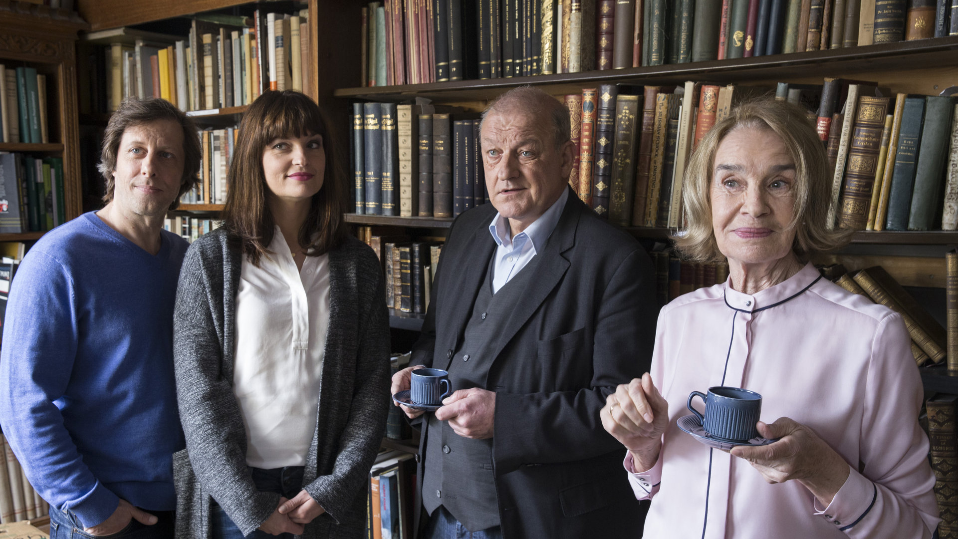 "Wilsberg - Der Betreuer": Ekki (Oliver Korittke), Alex (Ina Paule Klink), Wilsberg (Leonard Lansink) und Hanni Haffner (Gudrun Gundelach) stehen nebeneinander im Antiquariat. Wilsberg und Hanni Haffner halten Kaffeetassen in der Hand.