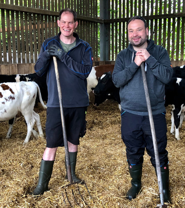 "Ein guter Grund zu feiern - Mariä Himmelfahrt mit Pater Nikodemus Schnabel": Pater Nikodemus Schnabel und Dennis Strothlüke in den Kuhstallungen beim Einstreuen.
