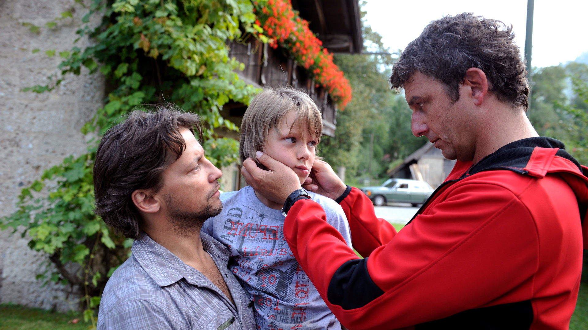 "Der Bergdoktor - Alles oder nichts": Stefan (Patrick Bach) hat seinen Sohn Philipp (Vincent Mauz) auf dem Arm. Neben ihnen steht der Bergdoktor Martin Gruber (Hans Sigl) und schaut sich Philipp an.