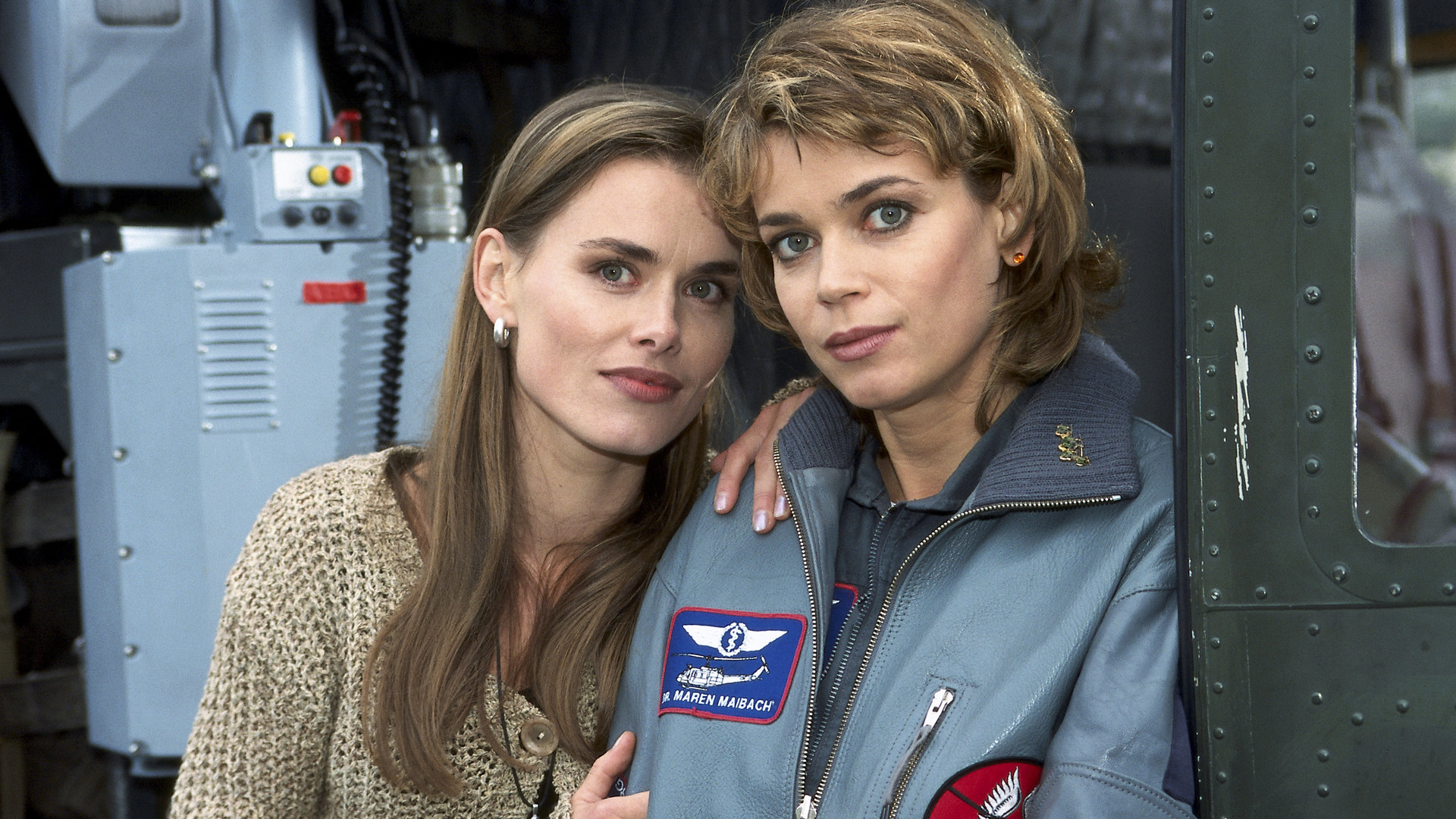 "Die Rettungsflieger - Ohne Vorwarnung": Maren (Gerit Kling) und ihre Schwester Kerstin (Andrea Lüdke) stehen nebeneinander in der offenen Tür des Hubschraubers und blicken in die Kamera.