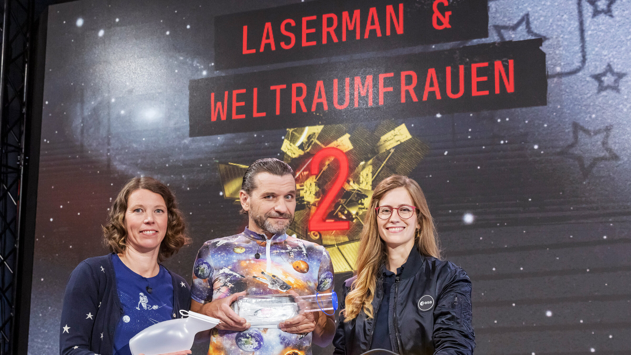 "Science Busters - Wer nichts weiß muss alles glauben - Laserman & Weltraumfrauen (2)": Martin Puntigam mit Ruth Grützbauch und Carmen Possnig.