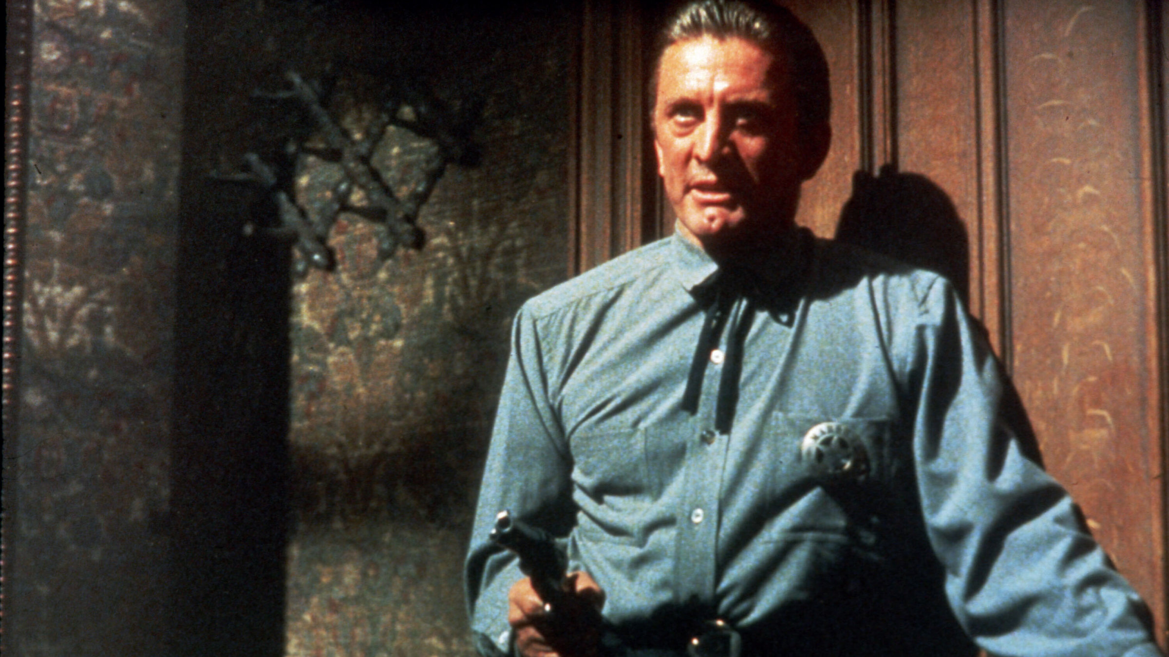 "Der letzte Zug von Gun Hill": Ein Mann mit Sheriffstern steht mit gezogener Pistole kampfbereit  in einem Zimmer.