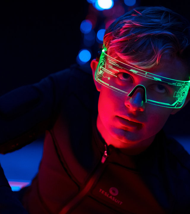 "Alex Rider - Schlange": Alex (Otto Farrant) liegt auf dem Boden eines verdunkelten Raums. Dabei trägt er einen hautengen Motion-Capture-Anzug und eine grün leuchtende Brille.