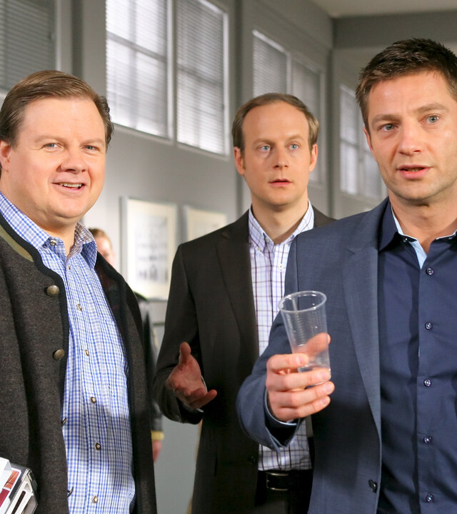 "Die Rosenheim-Cops - Ein Teich, eine Frosch, ein Mord": Im Flur des Kommissariats stehen die Kommissare Hansen (Igor Jeftic), Kollege Hartl (Michael A. Grimm) und Controller Seitz (Gábor Biedermann).