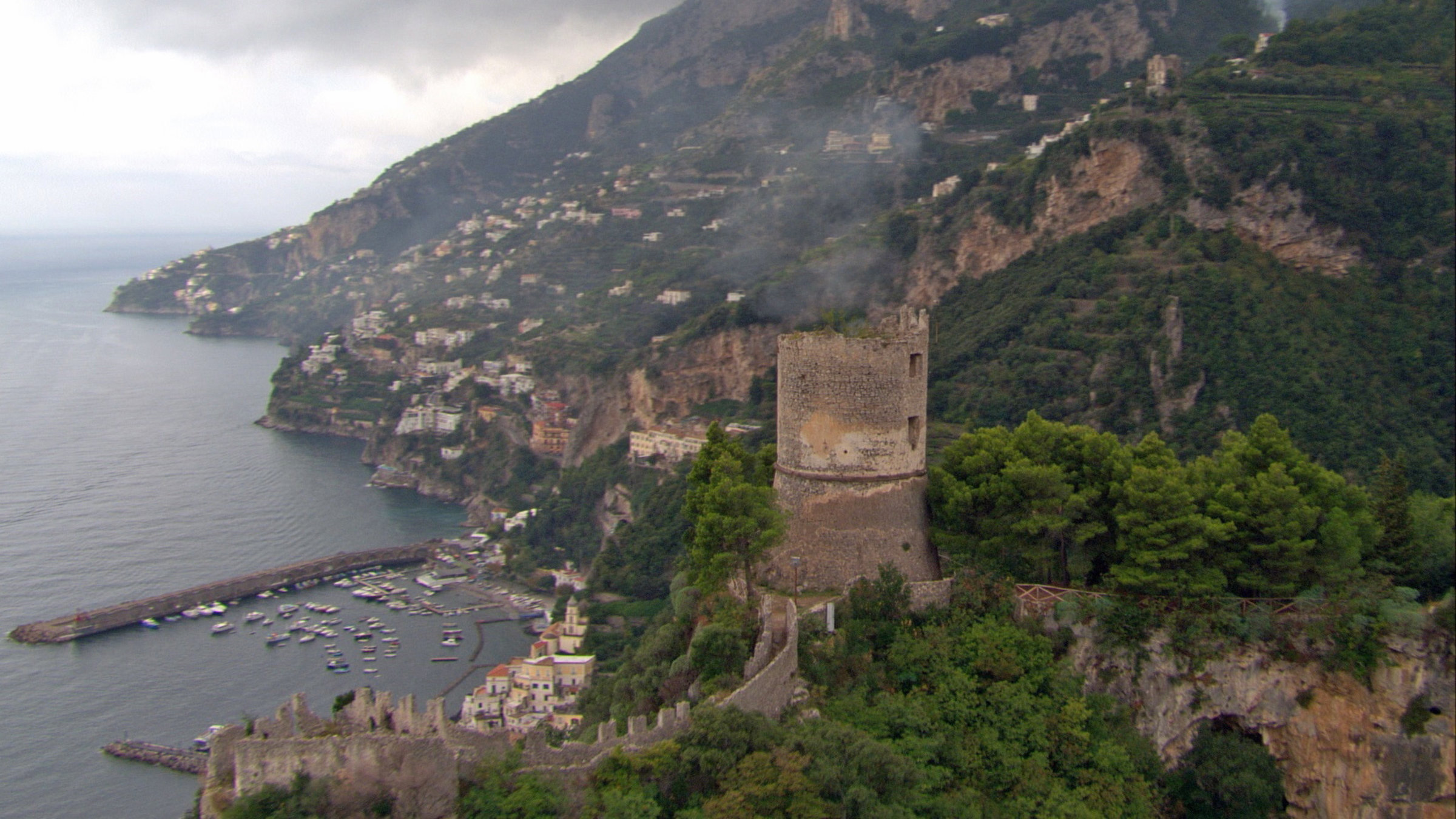 "Süditalien von oben": Küstenlandschaft der Amalfiküste mit Burgturm im Vordergrund.