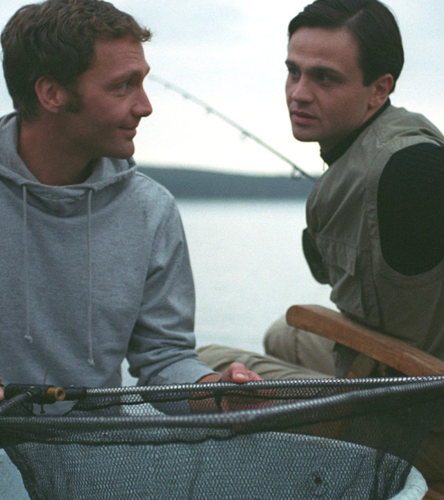 "Bianca - Wege zum Glück: Folge 40": Beim Angeln: Oliver (Patrik Fichte) und Pascal (Michael Rotschopf) sind auf dem Boot und sitzen nebeneinander. Oliver hält ein Fischernetz in der Hand und schaut Pascal freundlich an. Pascal dreht sich zu Oliver und wirkt etwas reserviert.