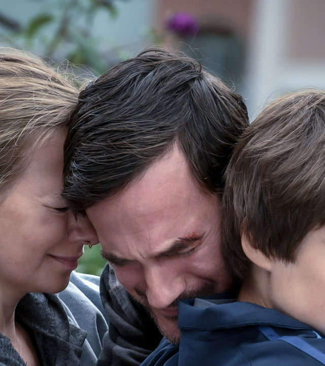 "SOKO Linz - Kältestarre": Anselm Kramer und (Sönke Möhring) und seine Kinder Julian (Leopold Pallua) und Sinia (Angelika Strabsen) liegen sich trauernd in den Armen. Sinia hält einen Plüsch-Tiger in der Hand.
