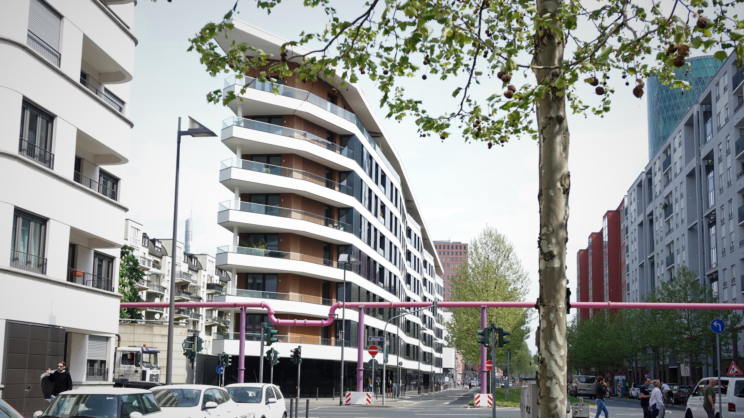 "planet e.: Planen, bauen, leben - Die Städte der Zukunft": Blick auf eine Straßenkreuzung in Frankfurt mit einem schmalen, modernen Gebäude.