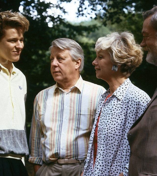 "Die Wicherts von nebenan: Der Unfall": In einem Wald. Hannelore (Maria Sebaldt), Eberhard (Stephan Orlac) und Graf Hasso (Friedrich Schütter) stehen neben Andy (Hendrik Martz) und Gaby (Roswitha Schreiner) und blicken das junge Paar fröhlich an.