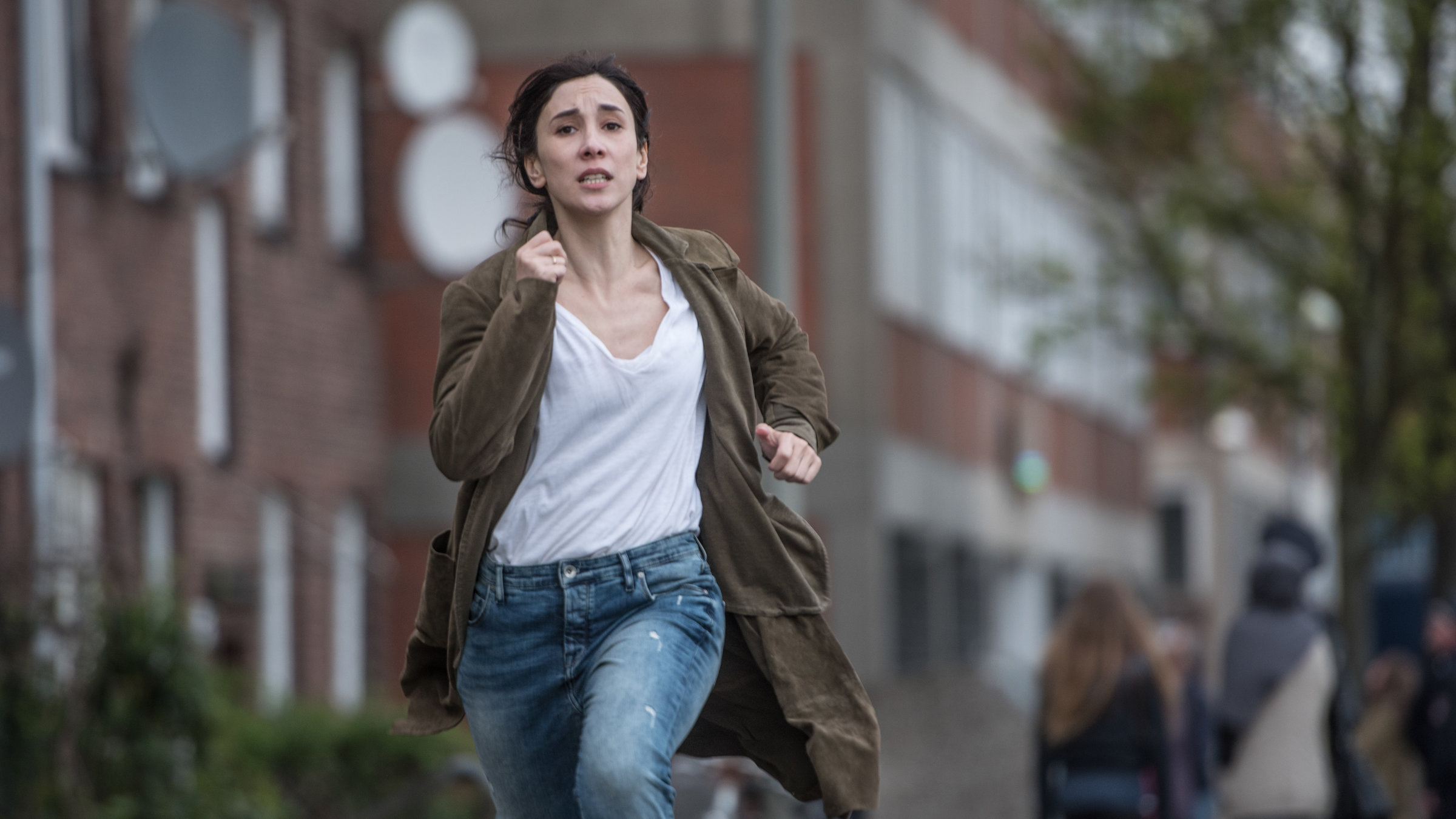 "Bruder – Schwarze Macht: Am Ende der Dunkelheit": Sibel (Sibel Kekilli) rennt mit erschrockenem Blick auf einem Gehweg.