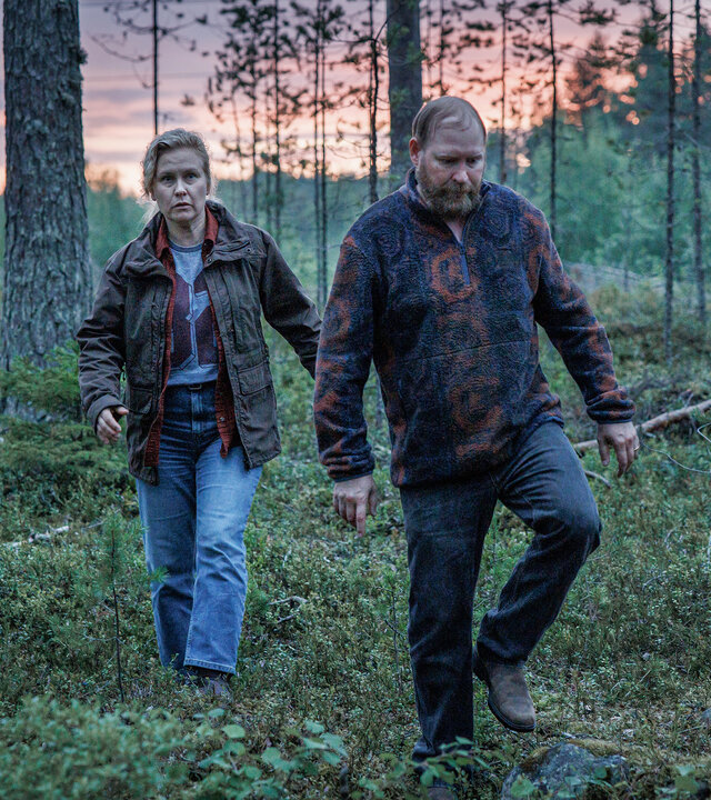 "Wolfssommer – Blutige Spuren - Wer bist du?": Hannah (Eva Melander) und Thomas (Henrik Dorsin) laufen in der Dämmerung über eine Lichtung im Wald.