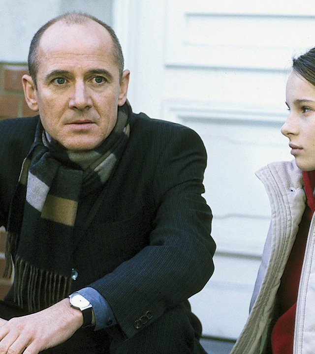 "Der letzte Zeuge - Der vergessene Tod": Dr. Robert Kolmaar (Ulrich Mühe) und Vicky Goll (Nicole Mieth) sitzen am Hauseingang auf einer Treppenstufe. Sie schweigen sich an.