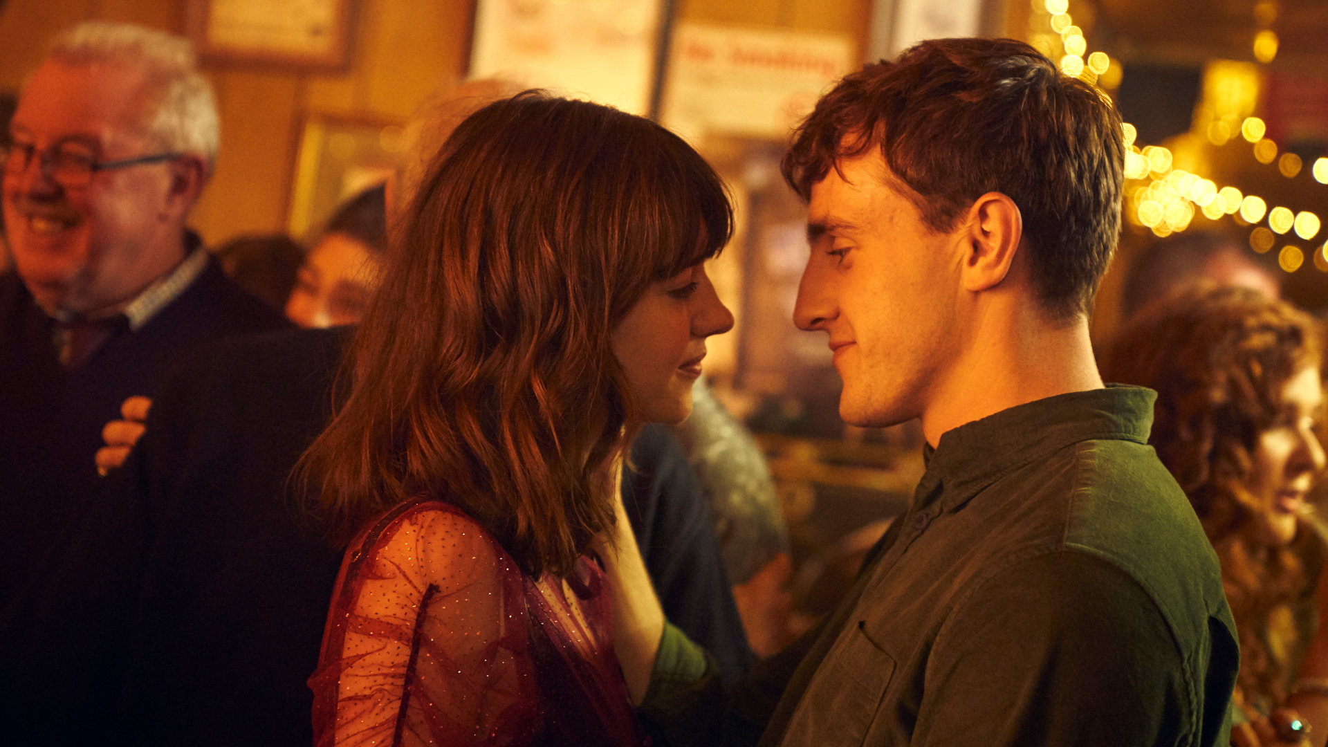 "Normal People - Liebe": Marianne (Daisy Edgar-Jones) und Connell (Paul Mescal) tanzen inmitten einer Menschenmenge und sie schauen sich innig an.