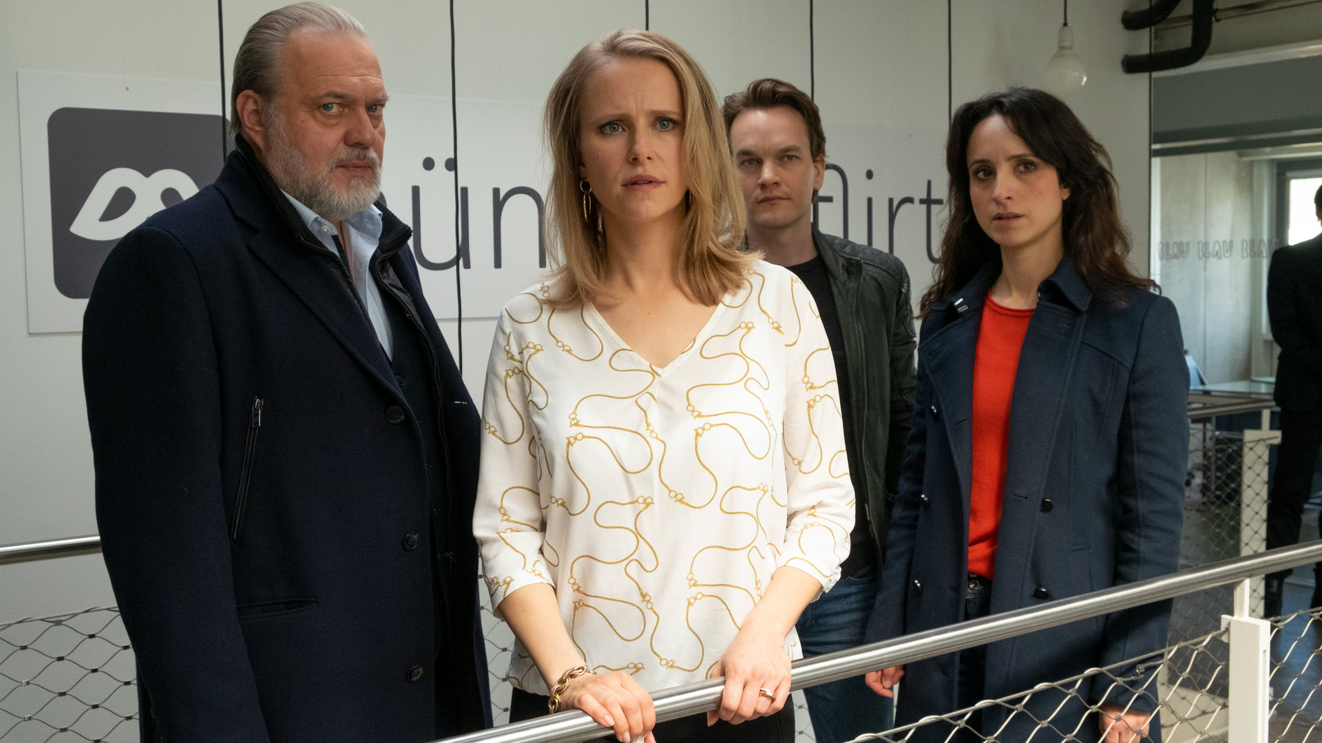 "Der Alte - Verletzte Gefühle": Hauptkommissar Richard Voss (Jan-Gregor Kremp) und seine Kollegen Tom Kupfer (Ludwig Blochberger) und Annabell Lorenz (Stephanie Stumph) stehen im Treppenhaus der Firma von Jasmin Wenzel (Susanne Bormann). Jasmin schaut entsetzt in Richtung Kamera. Voss und sein Team blicken interessiert in dieselbe Richtung.