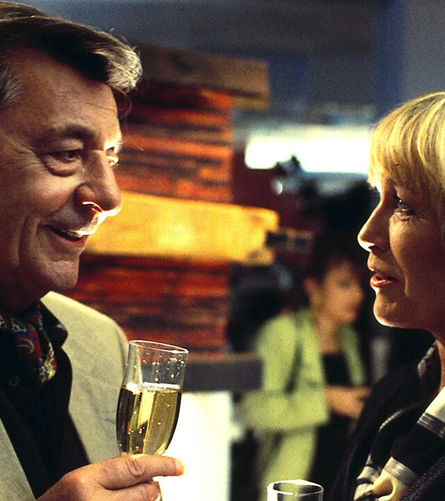 "Alle meine Töchter - Väter und Töchter": Berthold Sanwaldt (Günter Mack) und Ingrid (Monika Lundi) stehen sich gegenüber und unterhalten sich während beide ein Sektglas in der Hand halten.