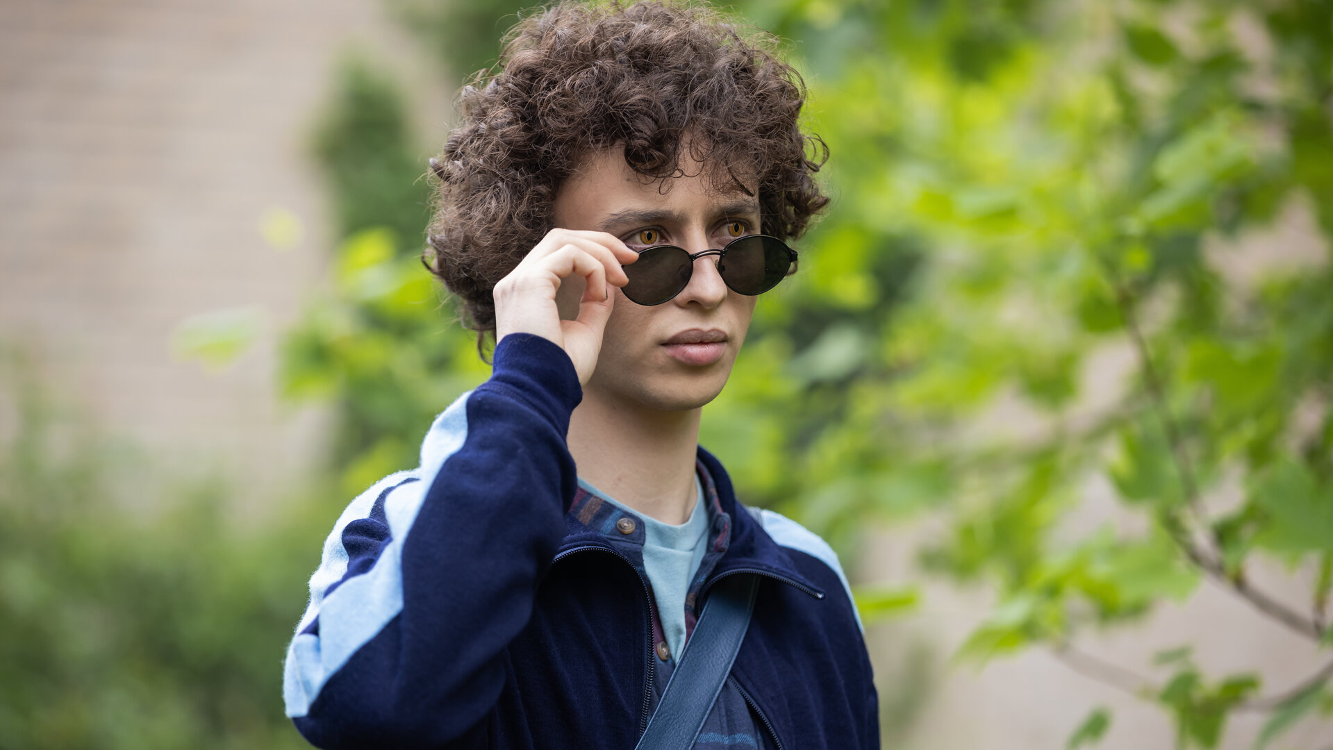 "Club der Dinosaurier - Beast Mode": Im Freien: Ben (Shadi Eck) setzt seine Sonnenbrille ab, wobei seine gelben Augen sichtbar werden.