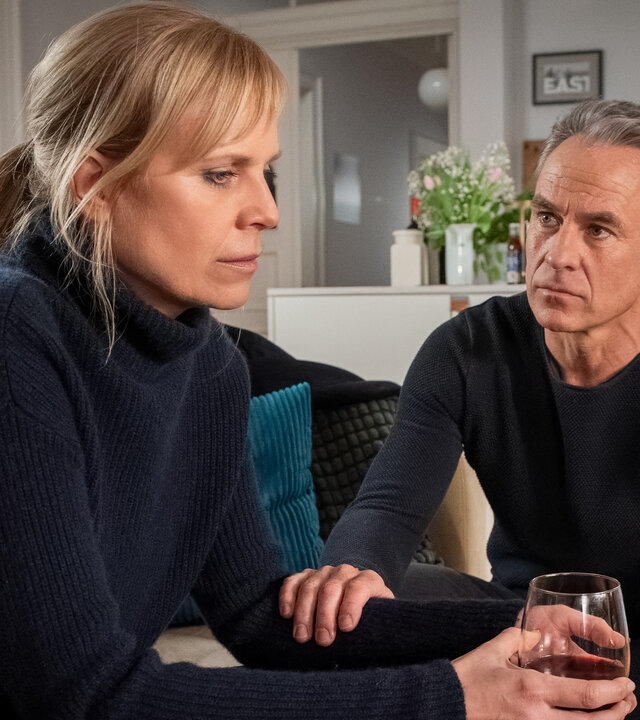 "SOKO Leipzig - Rechenschaft": Ina (Melanie Marschke) sitzt nachdenklich auf dem Sofa und hält ein Glas Wein in den Händen. Jan (Marco Girnth) hockt neben ihr und hat tröstend seine Hand auf ihren Arm gelegt.
