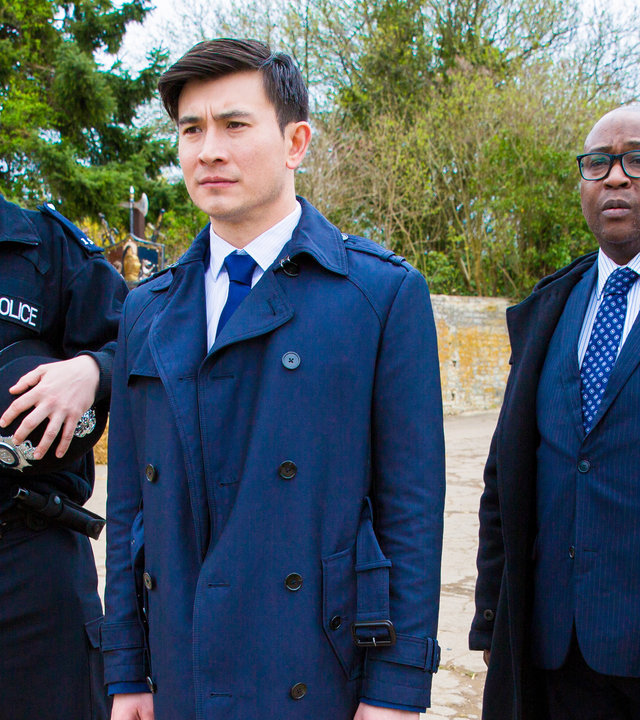 "Agatha Raisin – Und der tote Polizist Teil 2": Die Polizisten Billy Tulloch (Gerry McLaughlin), Bill Wong (Matt McCooey) und DCI Wilkes (Jason Barnett) stehen beim Showdown auf dem Lastwagenparkplatz nebeneinander.