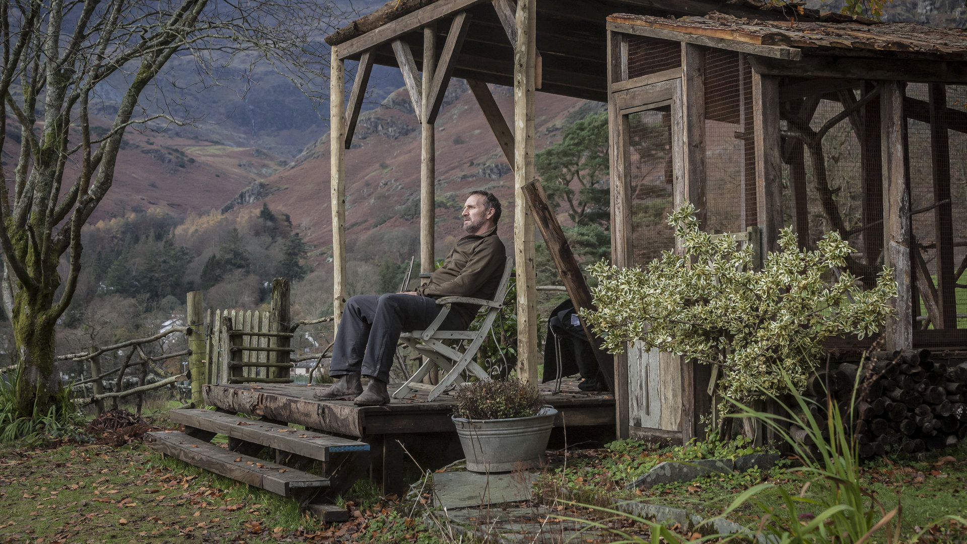 "Safe House - Verrat": Robert (Christopher Eccleston) sitzt nachdenklich in seinem Garten auf einem Stuhl.