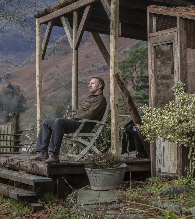 "Safe House - Verrat": Robert (Christopher Eccleston) sitzt nachdenklich in seinem Garten auf einem Stuhl.