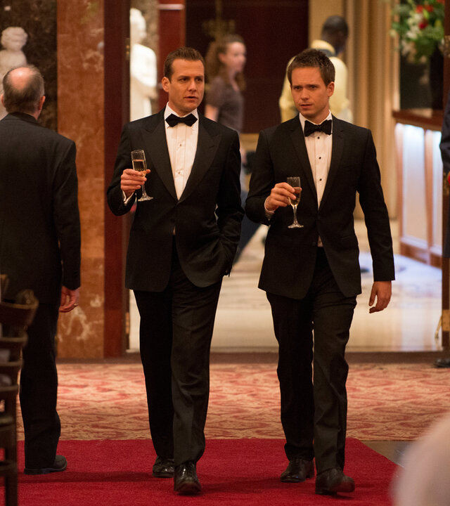 "Suits - Volles Risiko": Im Casino: Harvey (Gabriel Macht) und Mike (Patrick J. Adams) schreiten im Smoking über den roten Teppich, mit jeweils einem Sektglas in der Hand. Um sie herum herrscht geschäftiges Treiben in glamouröser Kulisse.